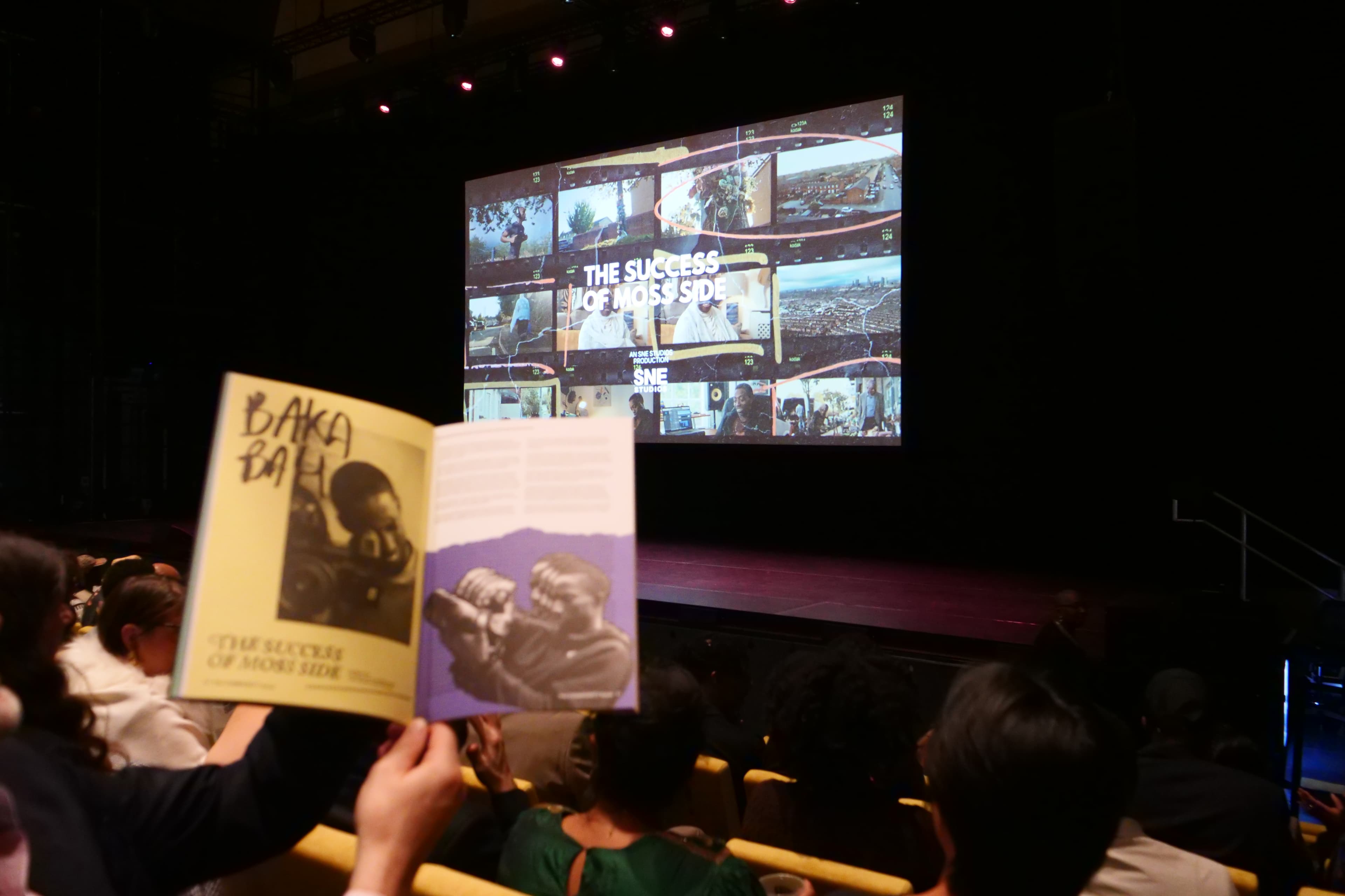 Audience member holding event booklet at The Success of Moss Side premiere